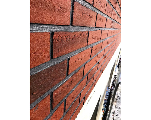 Gros plan d''une façade avec des briques rouges et des joints gris