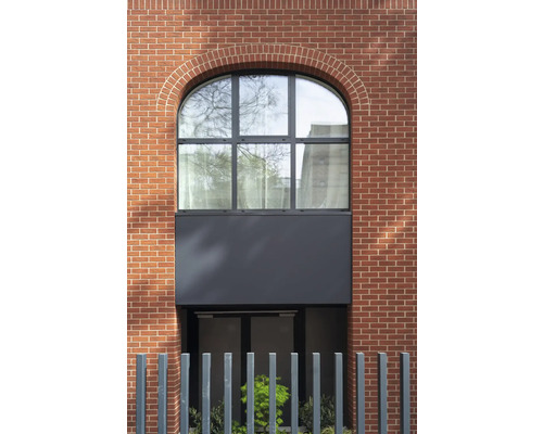 Façade d''un bâtiment avec maçonnerie en briques et fenêtre cintrée