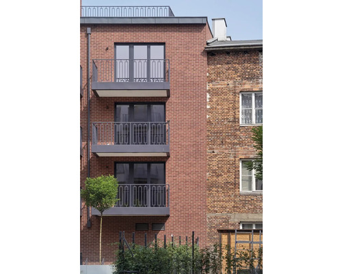 Façade d''un immeuble d''habitation avec des briques et des balcons.