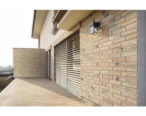 Façade de maison avec maçonnerie, stores et éclairage extérieur