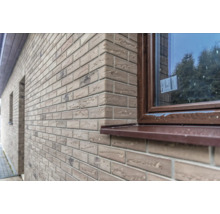 Extérieur d''une maison avec une façade en plaquettes de parement et une fenêtre