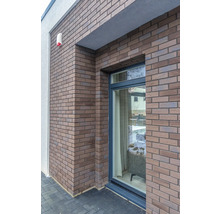 Mur de maison avec parement en briques et fenêtre