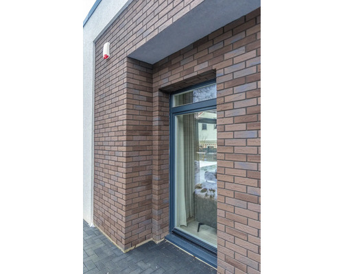 Mur de maison avec parement en briques et fenêtre