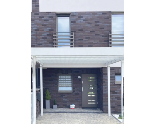 Façade de maison avec abri voiture, porte d''entrée et fenêtres au design moderne.