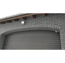 Garage avec façade en arc de pierre maçonnée et éclairage extérieur