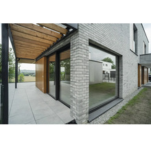 Vue extérieure d''une maison avec des murs en briques, une terrasse et une pergola