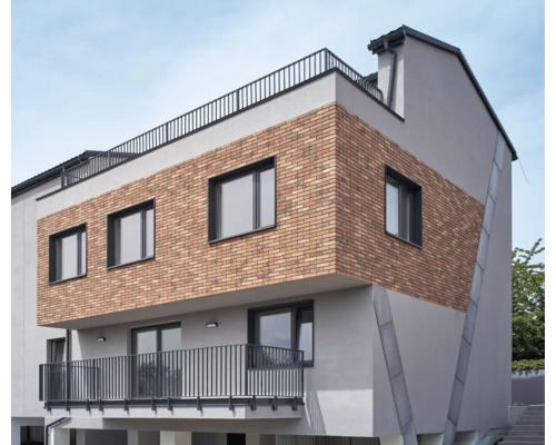 Bâtiment moderne avec façade en briques, fenêtres et balcon