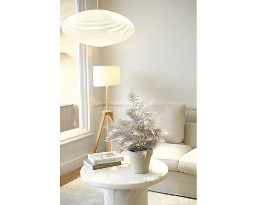 Dekorative künstliche Pflanze auf einem Beistelltisch in einem Wohnzimmer.