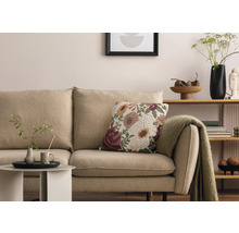 Scène de salon avec canapé beige, coussin décoratif à fleurs et table d''appoint