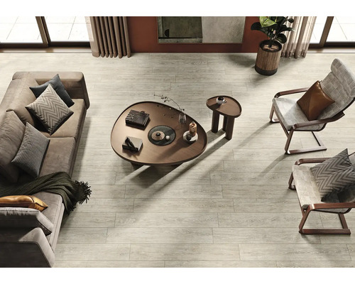 Photo d'intérieur d'un salon avec parquet gris clair, canapé, fauteuil et table basse.