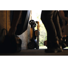 Projecteur de travail DeWalt plié avec roues de transport, rangé dans un atelier