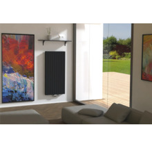 Modernes Wohnzimmer mit schwarzem Heizkörper, Kunstwerk und Blick ins Grüne.