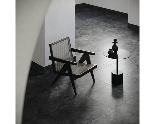 Innenaufnahme mit einem Sessel aus Rattan und einem Beistelltisch mit Dekoration