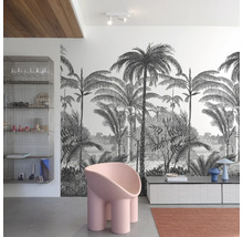 Salon avec papier peint tropical, fauteuil moderne et étagère métallique.