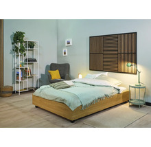 Chambre lumineuse avec lit, table de chevet, lampe, fauteuil, étagère et panneau mural pour une ambiance conviviale
