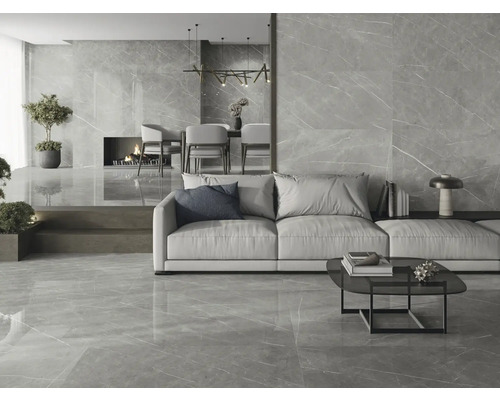 Heller Wohnraum mit Bodenfliesen und Wandfliesen in Marmoroptik, mit Couch, Tisch und Kamin.