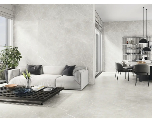 Espace de vie lumineux avec carrelage au sol et mural aspect marbre, canapé, table et coin repas