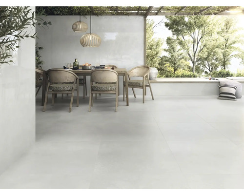 Terrasse lumineuse avec table à manger, chaises et carrelage de sol assorti pour l''extérieur.