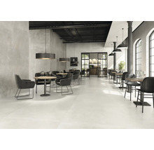 Restaurant spacieux avec tables, chaises et carrelage au sol.