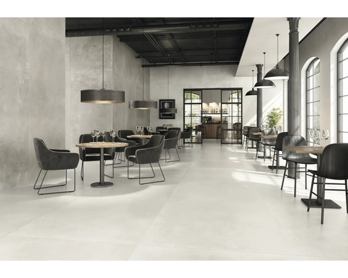 Restaurant spacieux avec tables, chaises et carrelage au sol.