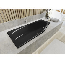 Eingebaute Badewanne in einem hellen Badezimmer mit Armatur, Handtuch und Dekoration