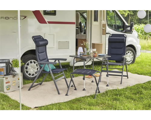 Campingplatz-Szene mit zwei Campingstühlen, einem Tisch und einem Wohnwagen