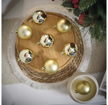 Dekorative goldene Weihnachtskugeln auf Holztablett