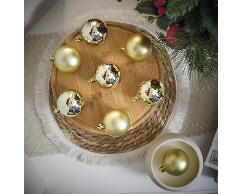 Dekorative goldene Weihnachtskugeln auf Holztablett