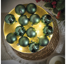 Boules de Noël décoratives vertes sur un plateau en bois lumineux pour décorations festives