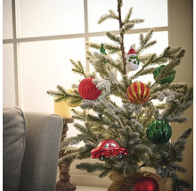 Sapin de Noël décoré avec des boules de Noël et une décoration de voiture devant une fenêtre