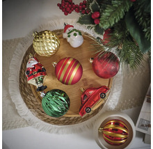 Différentes boules de Noël et décorations sur un plateau en bois rond