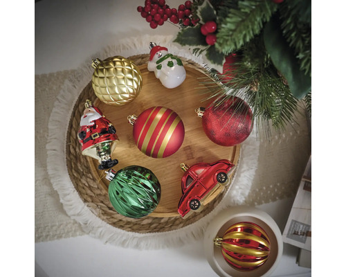 Différentes boules de Noël et décorations sur un plateau en bois rond