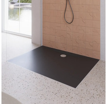Receveur de douche noir dans une salle de bains avec mur carrelé et douche.