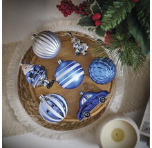 Boules de Noël décoratives de différentes formes sur un plateau en bois