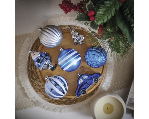 Boules de Noël décoratives de différentes formes sur un plateau en bois