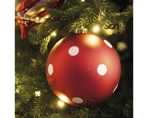 Sapin de Noël avec boule de Noël rouge et pois blancs