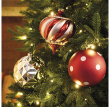 Trois boules de Noël sur un sapin de Noël avec éclairage.