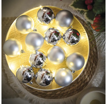 Boules de Noël argentées sur un plateau en bois illuminé