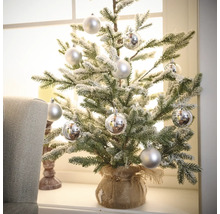 Petit sapin de Noël artificiel décoratif avec boules argentées dans un sac de jute