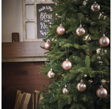 Sapin de Noël décoré avec boules devant la cheminée