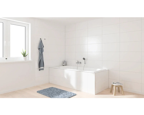 Salle de bain claire avec baignoire, fenêtre et serviette