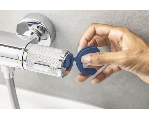 Main fixant un outil bleu sur un robinet
