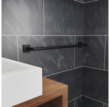 Porte-serviettes noir dans une salle de bain avec lavabo et carreaux gris