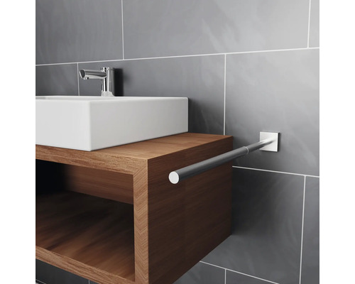 Lavabo avec meuble bas en bois et porte-serviettes dans la salle de bain