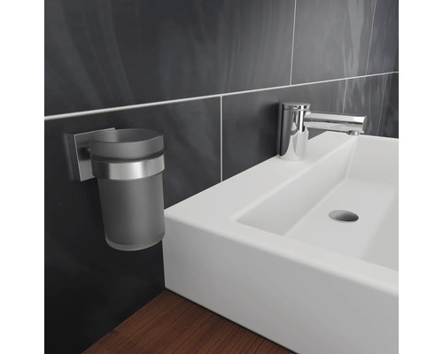 Gros plan d''un lavabo avec robinet et porte-gobelet pour brosse à dents dans une salle de bains