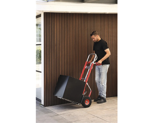 Eine Person transportiert mit einer Sackkarre einen Karton.