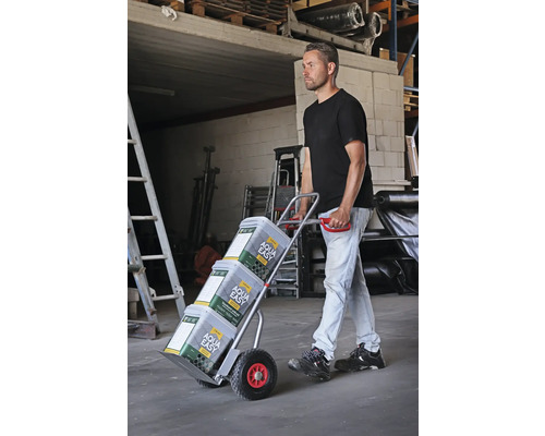 Un homme transporte des seaux de peinture avec un diable