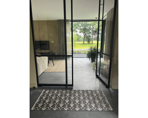 Intérieur avec un tapis à motifs devant une porte vitrée ouverte