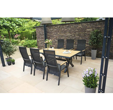 Scène de jardin avec table à manger et chaises sur une terrasse.