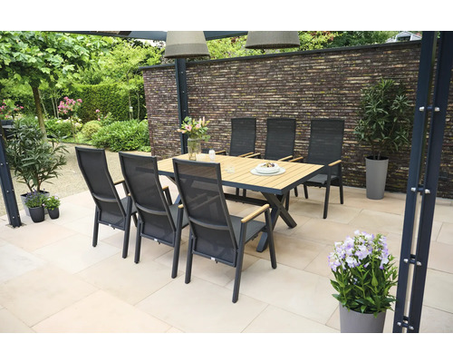 Scène de jardin avec table à manger et chaises sur une terrasse.